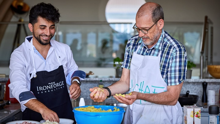 Deux hommes cuisinent dans une cuisine d'entreprise.