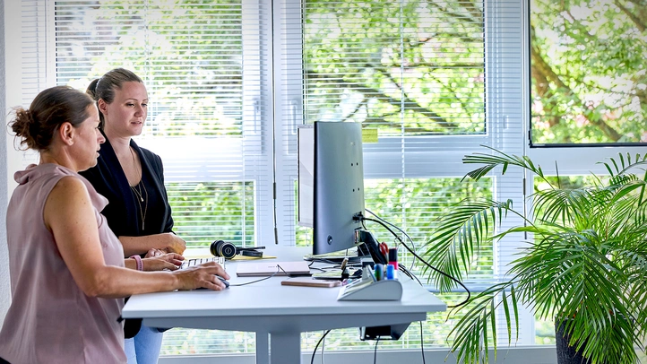 Zwei Kolleginnen an Stehpult