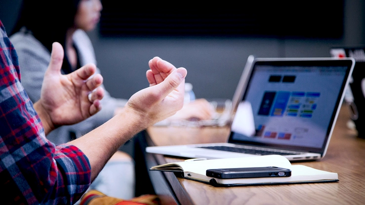Laptop, Smartphone in Nähe von Person in einer Besprechung