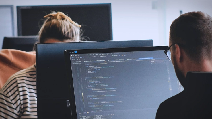 Zwei Personen arbeiten im Büro am PC.