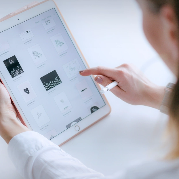 Une femme tape sur une tablette.