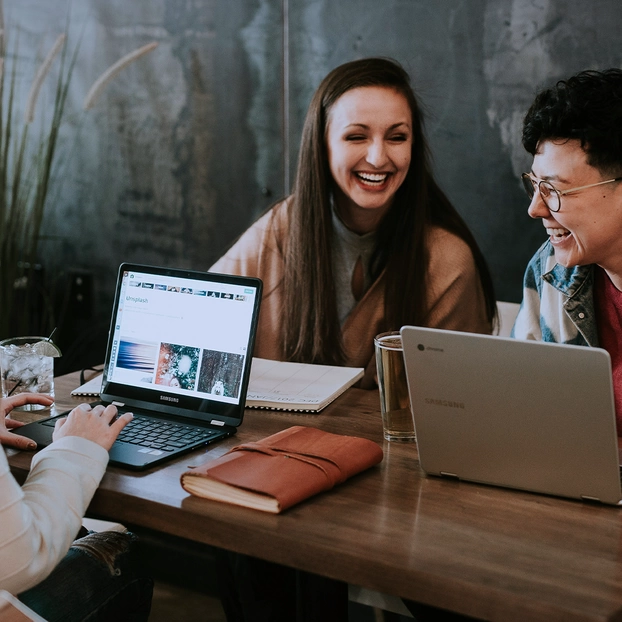 Trois femmes se consultent à une table.