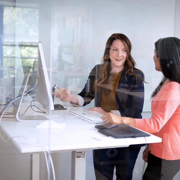 Zwei Frauen reden am PC.