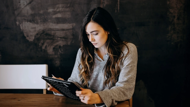 A woman working on a tablet.